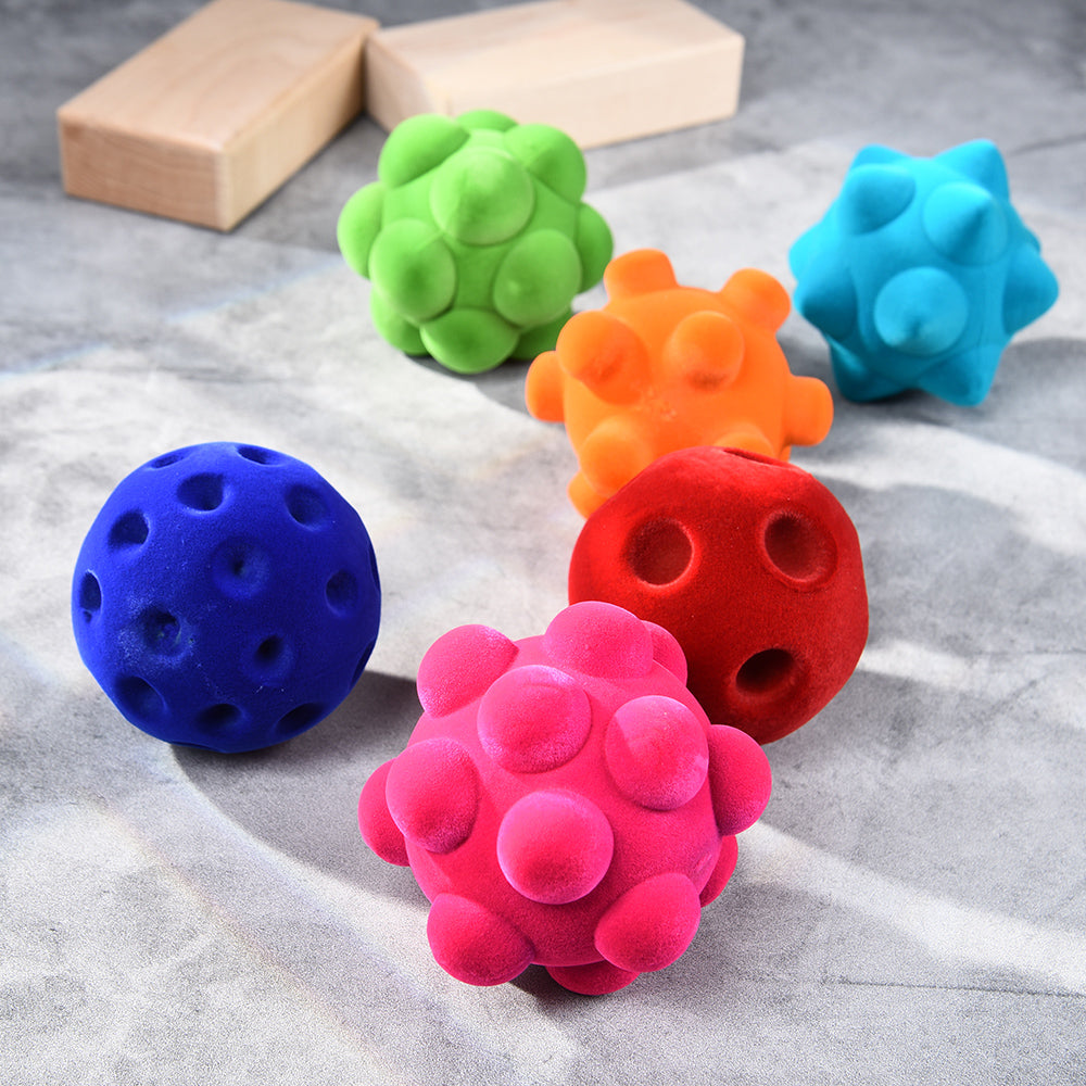 Rubbabu® Standard Ball Assortment with two blue balls, one pink ball, one orange ball, one green ball, and one red ball. Each ball has different textures.