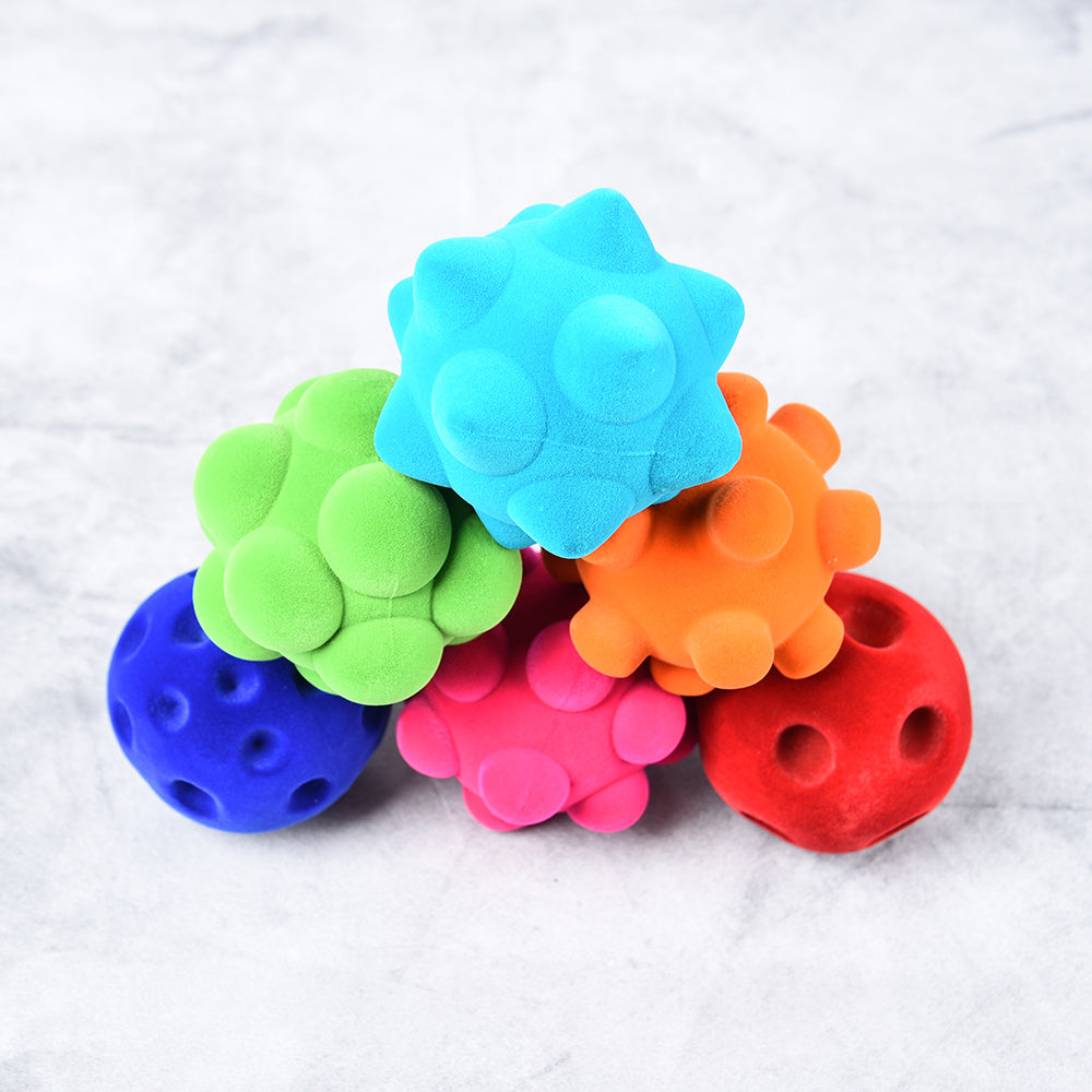 Rubbabu® Standard Ball Assortment with two blue balls, one pink ball, one orange ball, one green ball, and one red ball. Each ball has different textures.