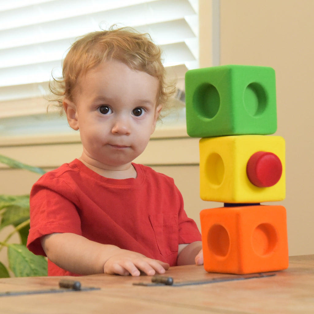 Boy playing with the Rubbabu® 13 PC Rubbablox Building Blocks with 6 Large Blocks and 7 Connectors in Bright Colors